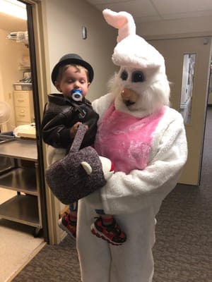 Child with a costumed Easter Bunny in a hallway