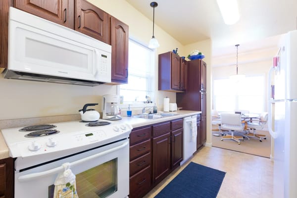 Bright kitchen space with dining area in background