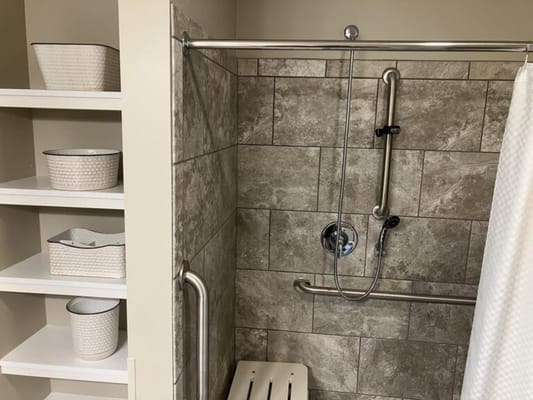 Accessible shower with shelving in a private bathroom