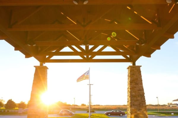 Entrance of a senior living facility with American flag