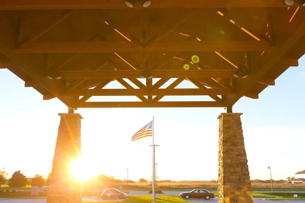 Entrance of a senior living facility with American flag