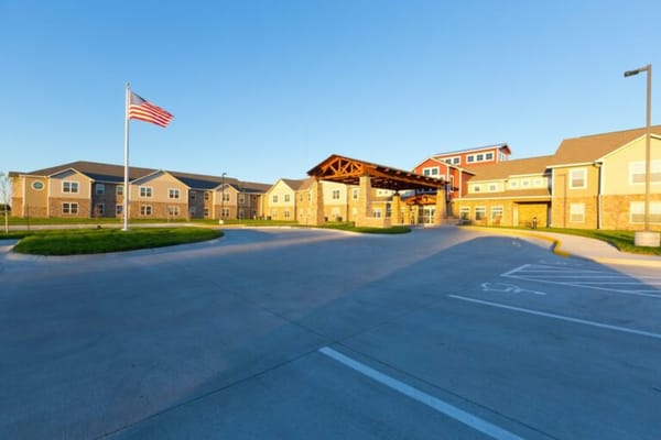 Exterior view of an assisted living facility with flag