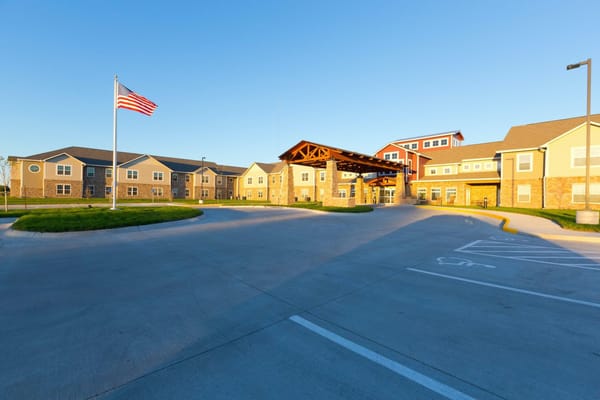 Exterior view of an assisted living facility with flag