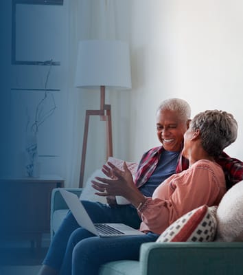 Two seniors chatting in a cozy common area
