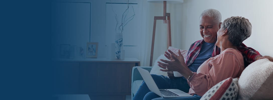 Two seniors enjoying conversation on a sofa