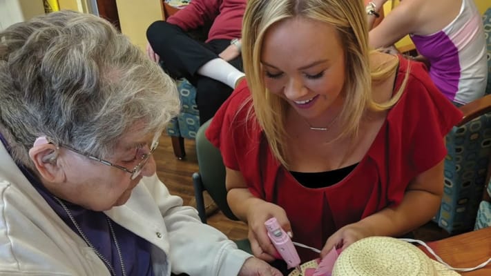 Resident and staff member engaging in a crafting activity