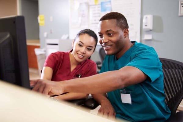 Two staff members collaborating at a computer