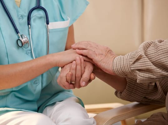A caregiver holding hands with a resident