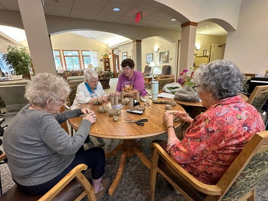 Residents engaged in a crafting activity around a table