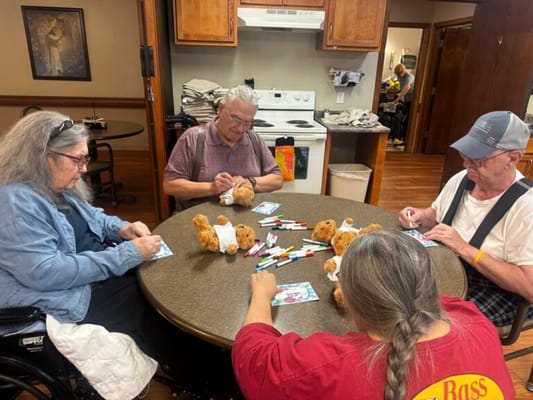Residents engaged in craft activity with teddy bears