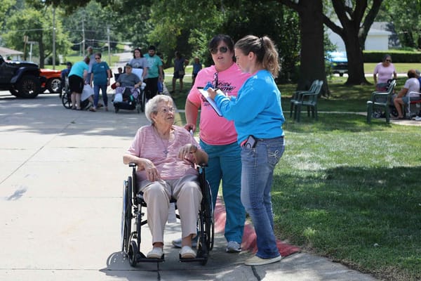 Residents and staff engaging outdoors on a sunny day