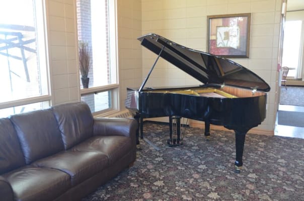Piano in a cozy common area with a couch