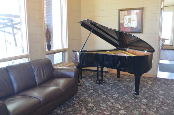 Piano in a cozy common area with a couch