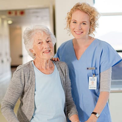 Resident and staff member smiling together in a facility