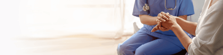 Healthcare professional holding a resident's hand