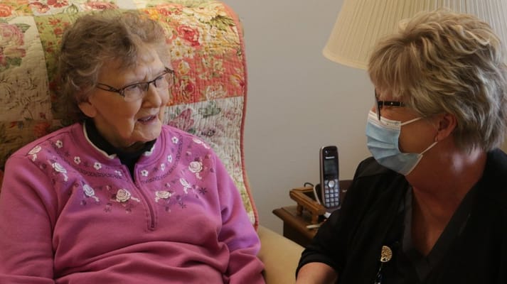 Staff member chatting with a resident in a cozy room