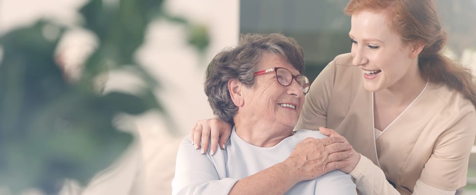 A caregiver smiling with a resident in a cozy setting