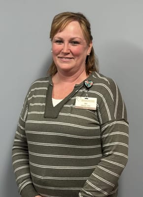 Staff member posing in front of a gray wall
