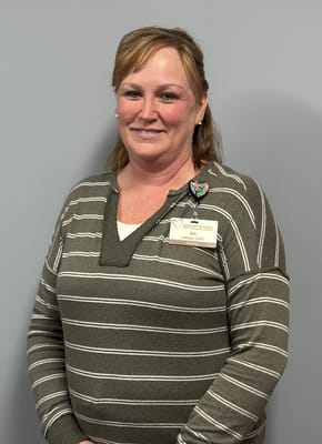 Staff member posing in front of a gray wall