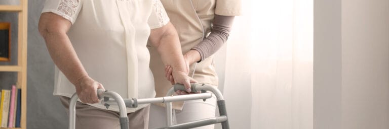 Care staff assisting a resident with a walker
