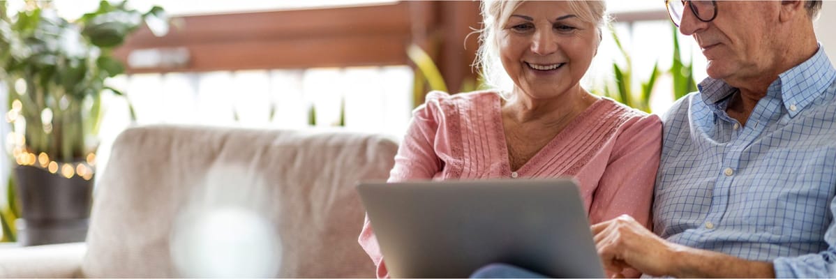 Two seniors enjoying a tablet together in a cozy setting