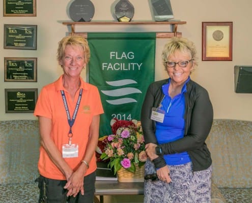 Two staff members standing together in a facility interior