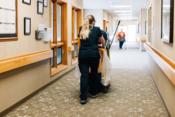 Staff member cleaning in a hallway of the facility