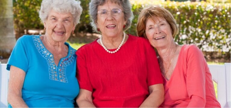 Three happy residents smiling outdoors