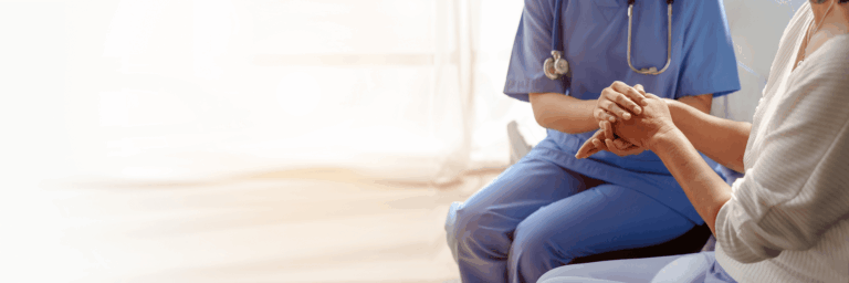 A caregiver holding hands with a resident in a warm setting