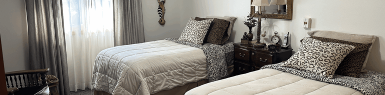 A private resident room with two beds and decor