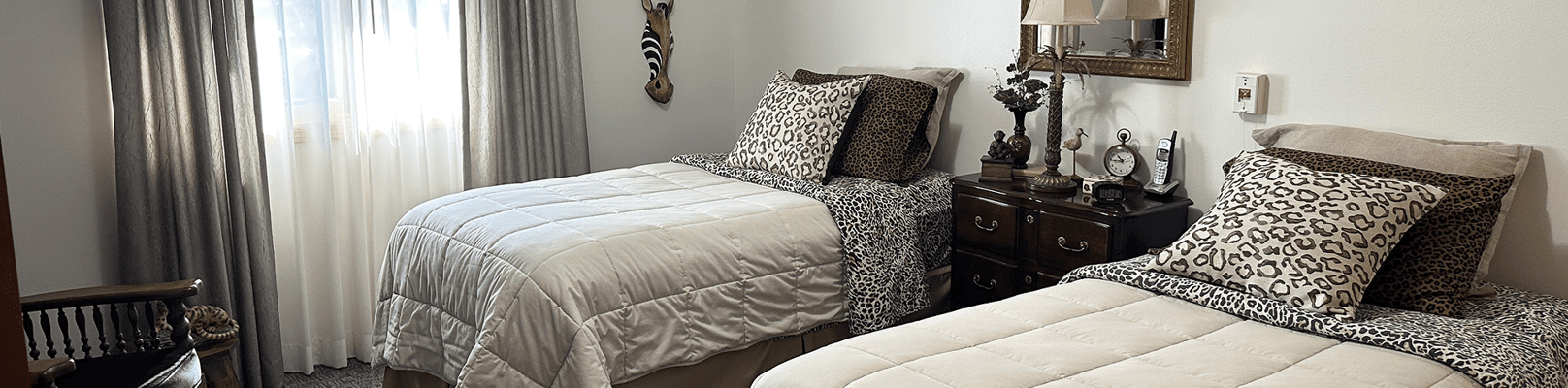 A private resident room with two beds and decor