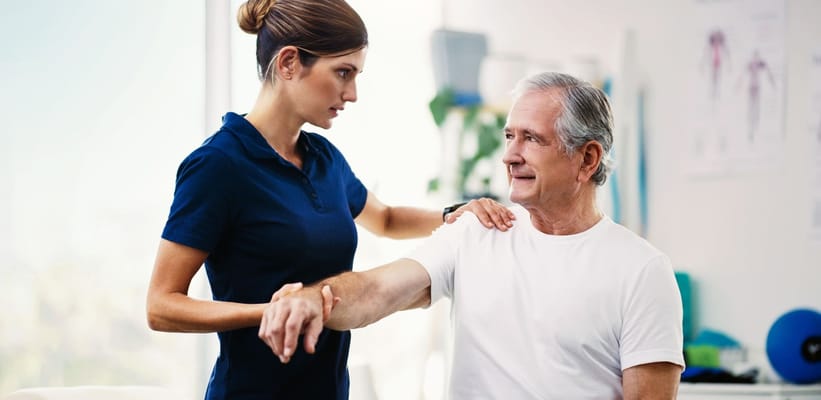 Therapist assisting a senior resident in rehabilitation