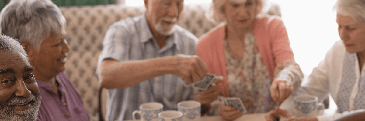 Residents playing cards in a bright indoor space