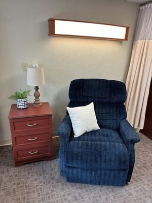 Cozy armchair beside a nightstand in a resident room