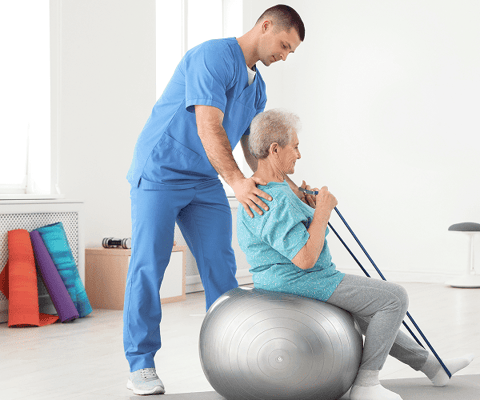 Resident participating in a fitness activity with staff assistance