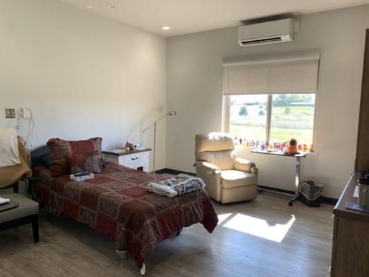 Interior view of a resident room with a bed and chair