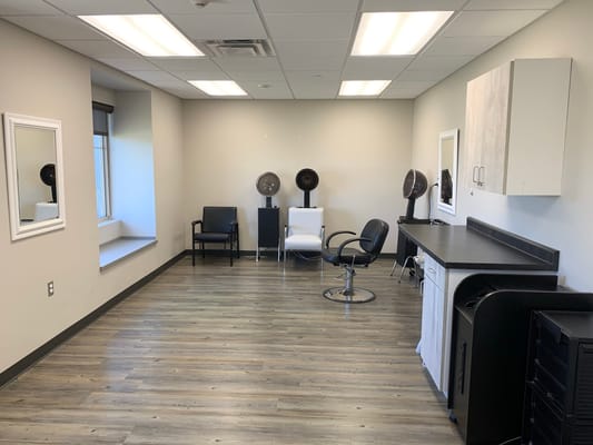 Bright and clean hair salon area with chairs and mirrors