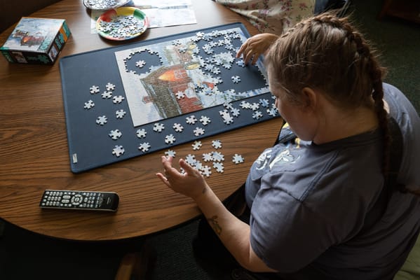 Resident working on a jigsaw puzzle in a common area