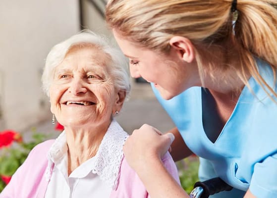 Caregiver smiling with a senior resident outdoors