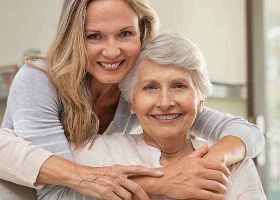 A caregiver and a resident smiling together
