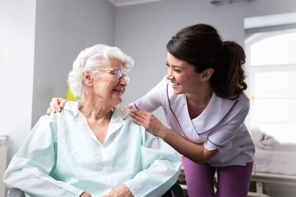 Nurse interacting and smiling with a resident in a bright room