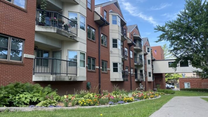 Exterior view of a senior living facility with gardens