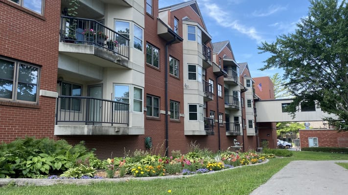 Exterior view of a senior living facility with gardens