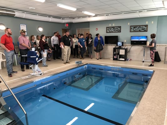 Group of people observing a therapy pool demonstration