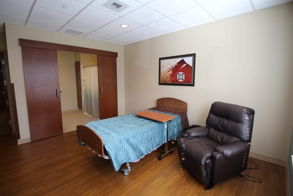 A private resident room with a bed and recliner chair