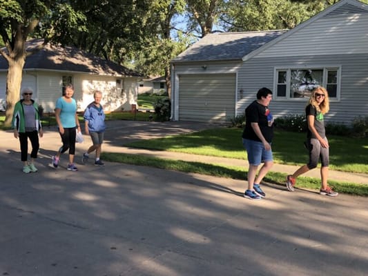 Residents and staff walking together in a pleasant outdoor setting