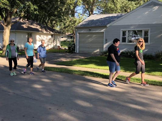 Residents and staff walking together in a pleasant outdoor setting