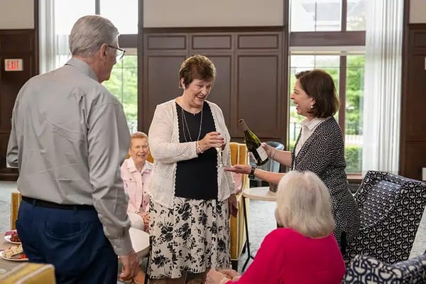 Residents celebrating with drinks in a common area