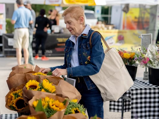A woman enjoying a flower market outdoors