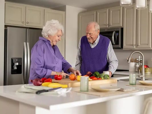 Elderly couple cooking together in a modern kitchen